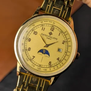 Close up of gold tone luxury watch with moonphase and date display