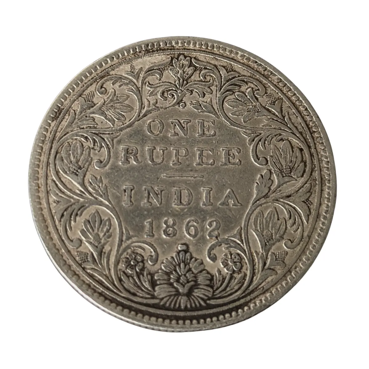 Reverse side of 1862 One Rupee India silver coin featuring floral Victorian design and “ONE RUPEE INDIA 1862” text
