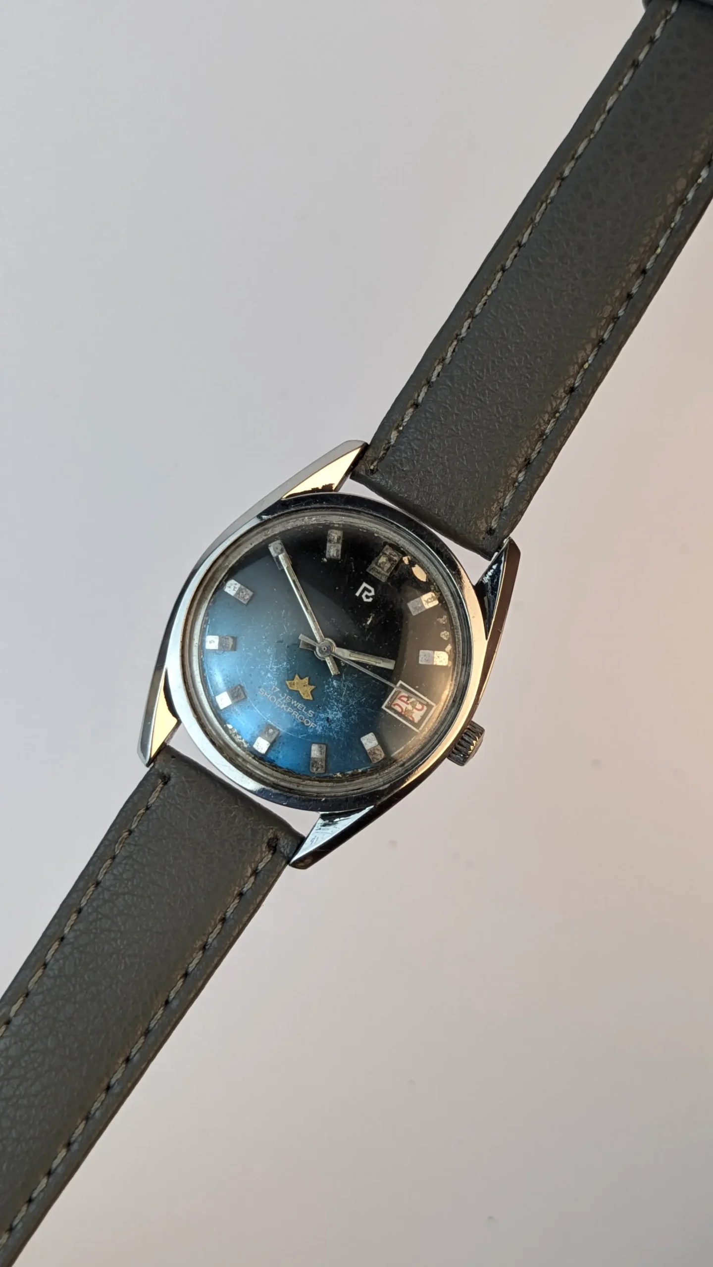 Vintage 35mm watch worn on wrist with grey strap