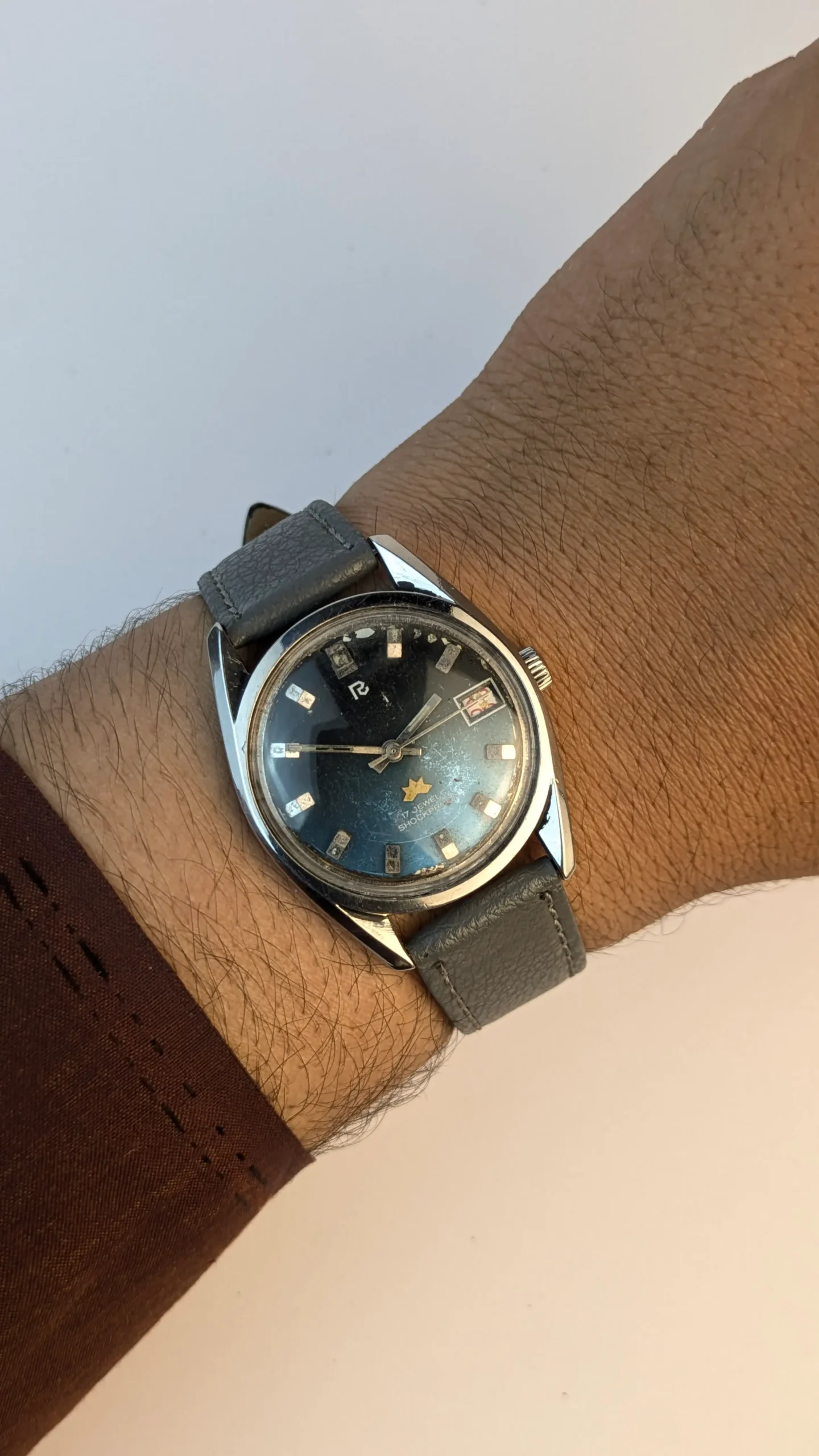 Vintage 35mm watch worn on wrist with grey strap