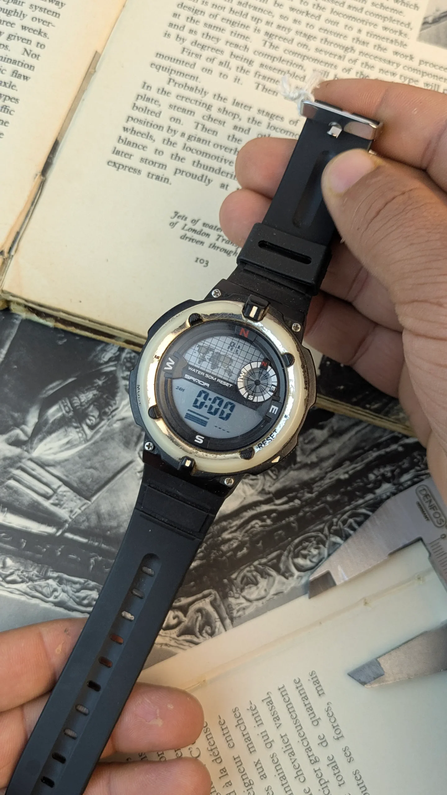 Angled front view of Sanda outdoor digital watch with black resin strap and silver tone bezel
