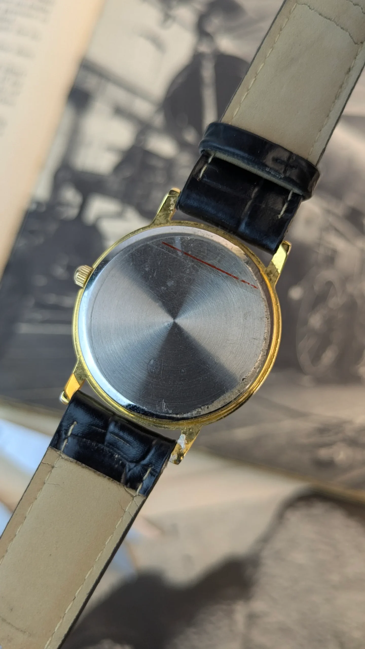 Back side of vintage wristwatch showing stainless steel caseback