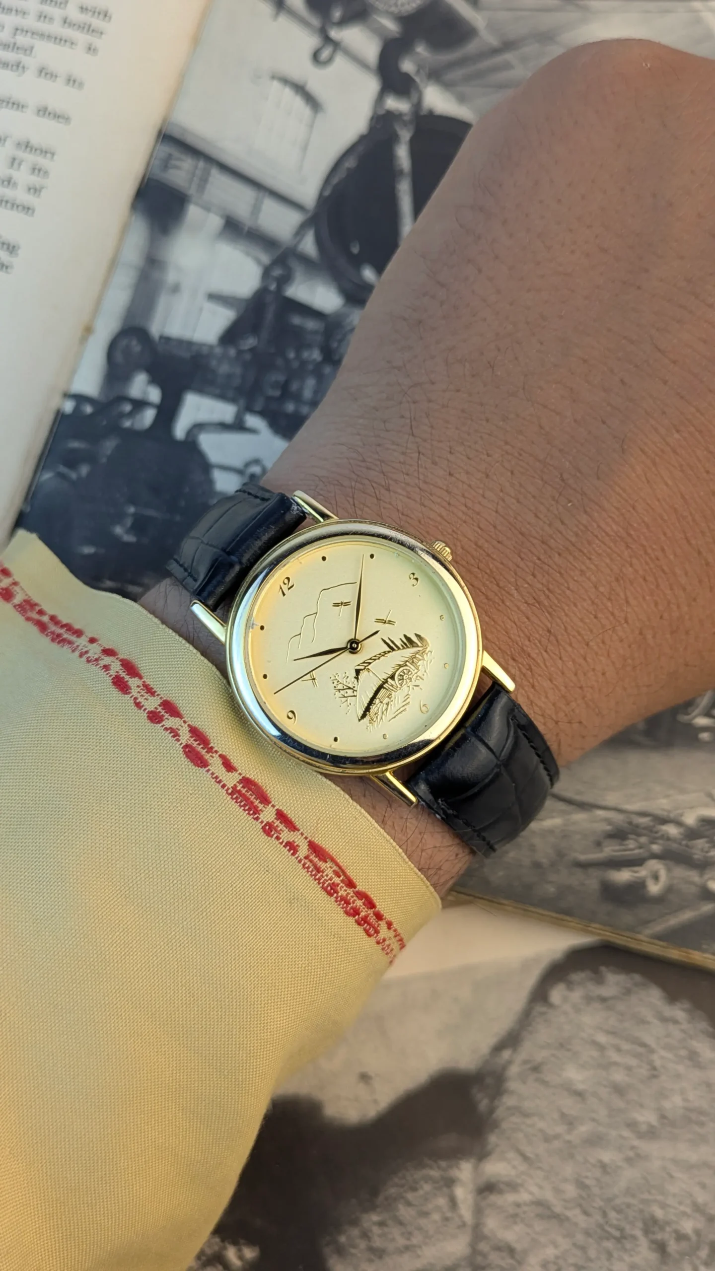 Vintage minimalist watch worn on wrist with traditional clothing