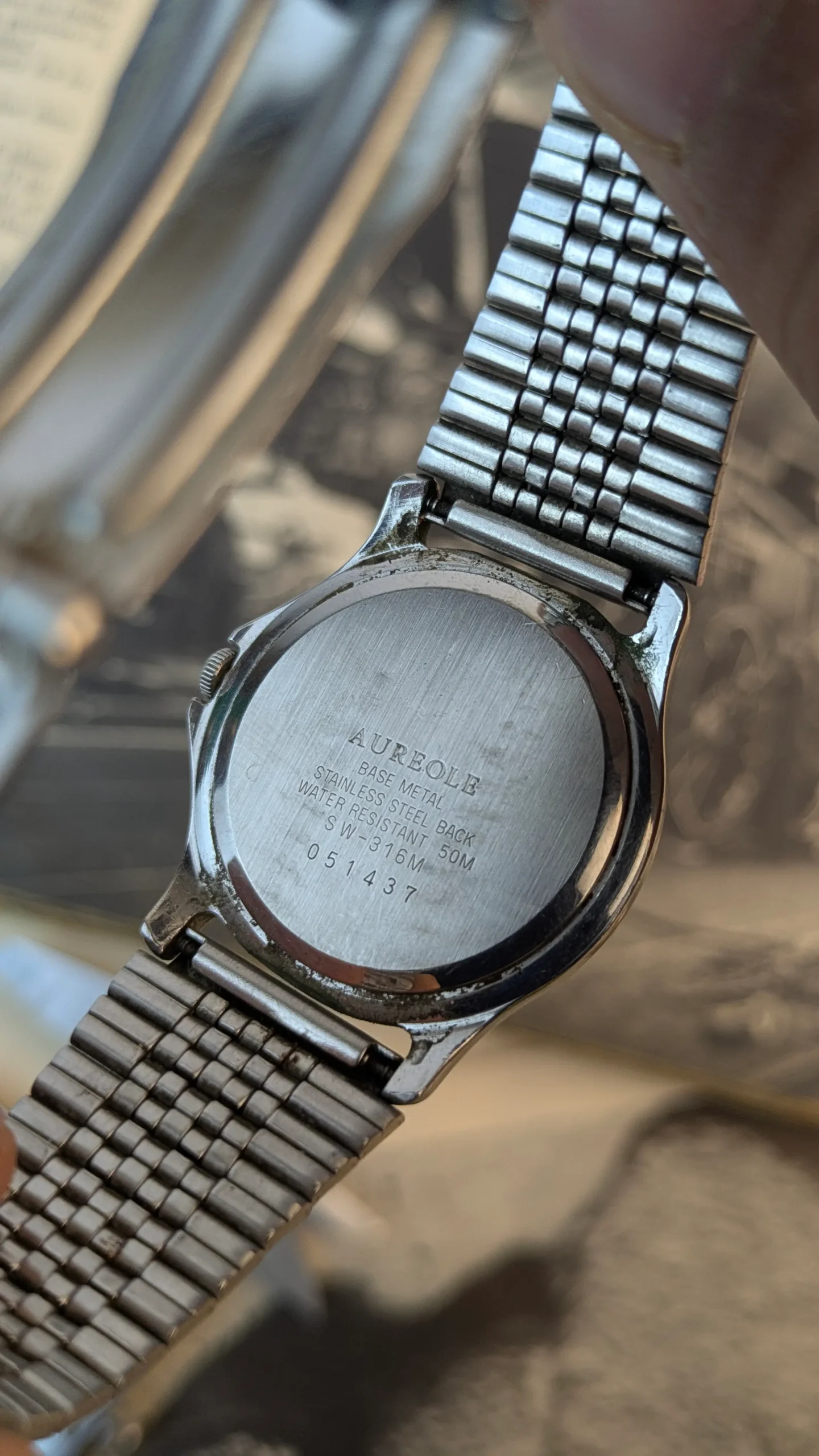 Back view of vintage Aureole Quartz SW-316M watch showing stainless steel caseback markings