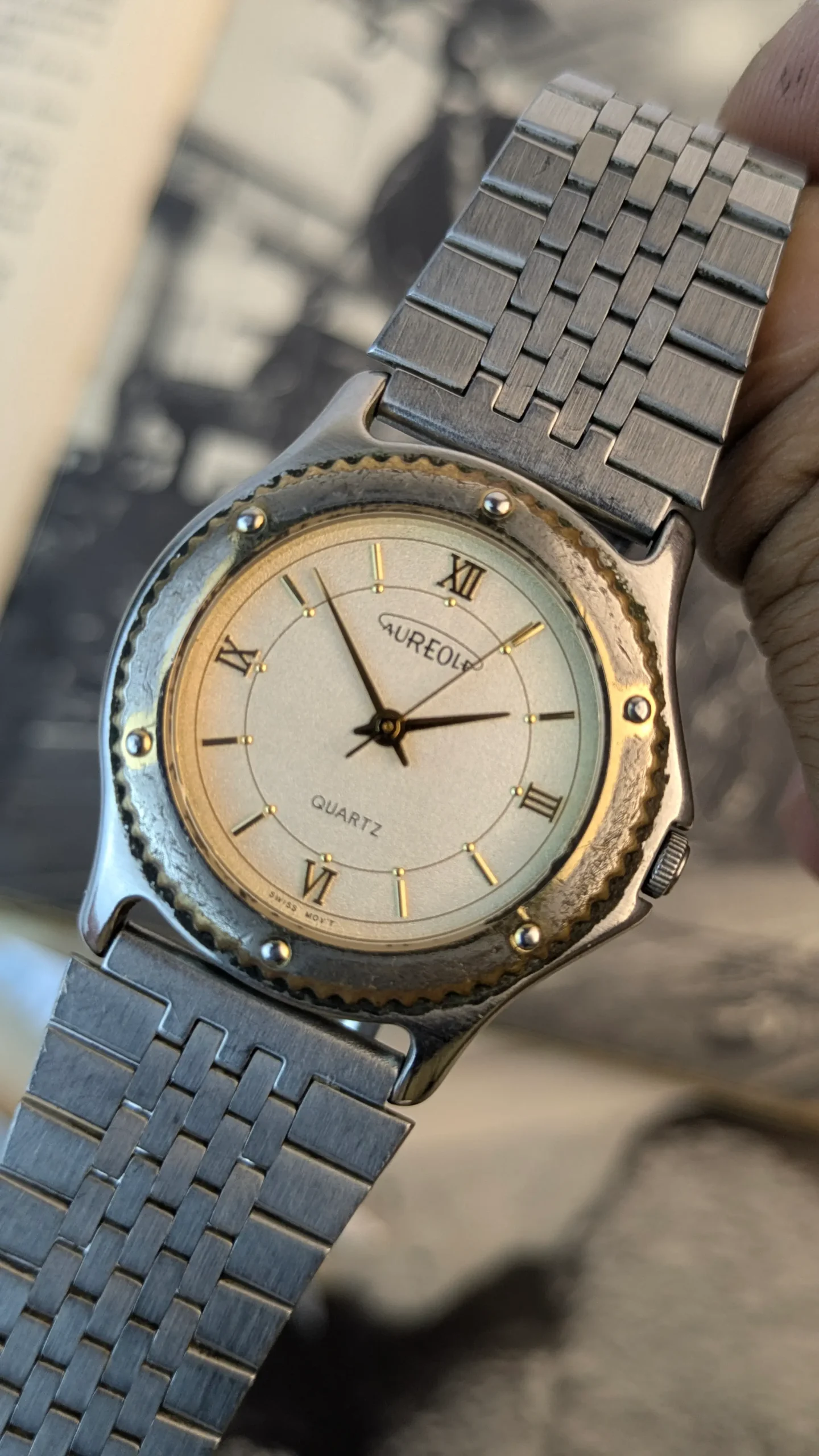 Close-up of Aureole quartz watch dial with Roman numerals and gold-tone markers