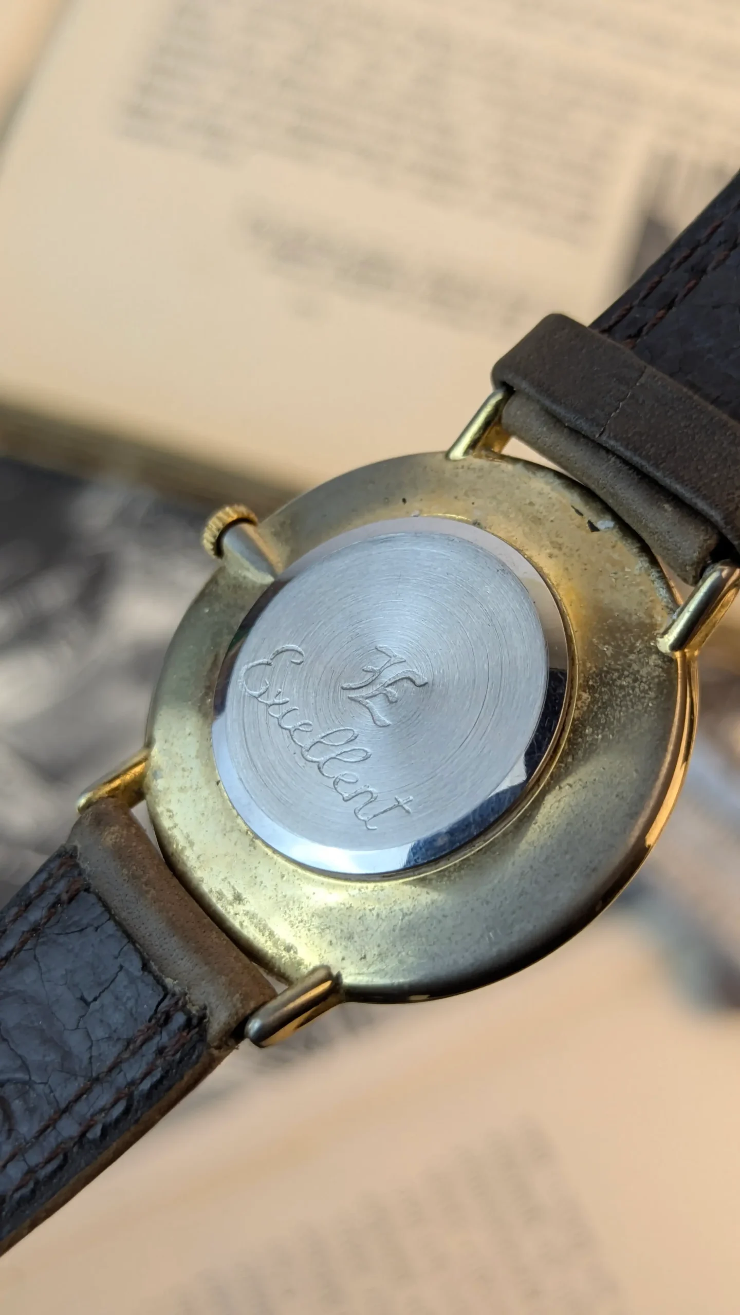 Back case of vintage Excellent watch showing branding.