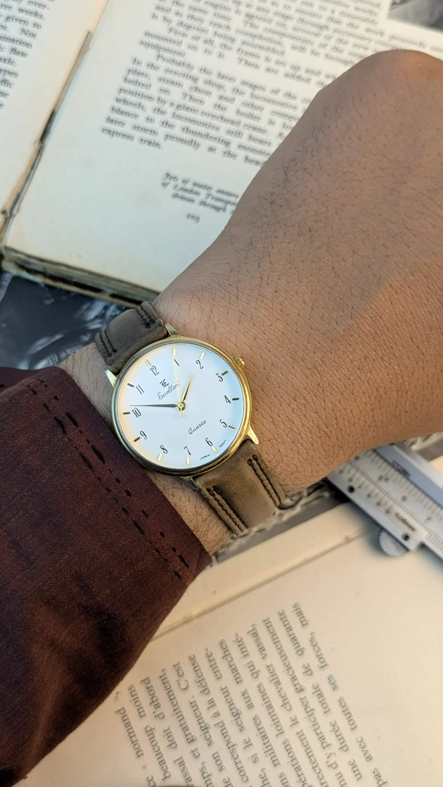 Excellent quartz watch worn on wrist with brown leather strap.