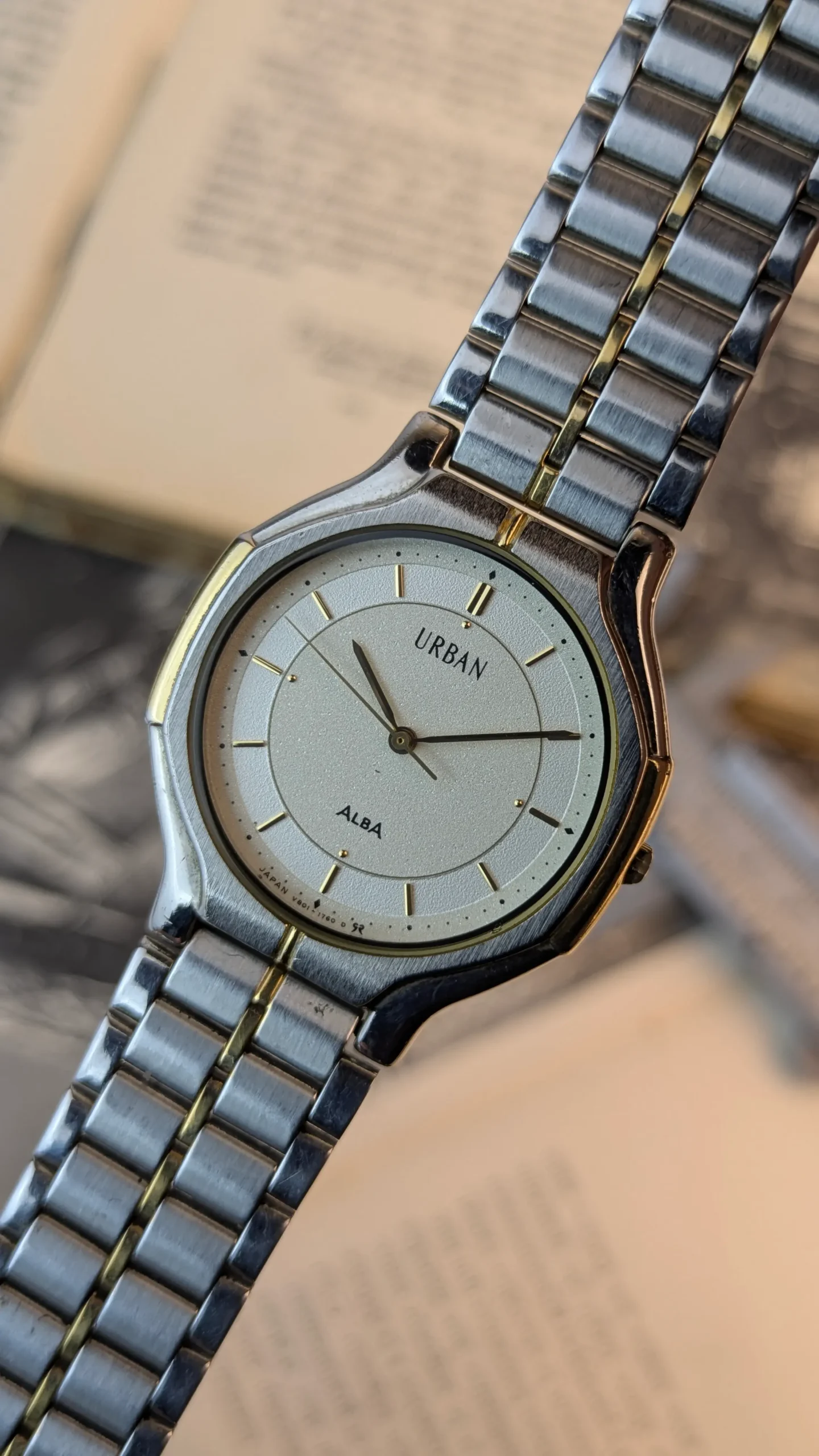 Close-up of ALBA Urban silver dial with gold-tone markers.