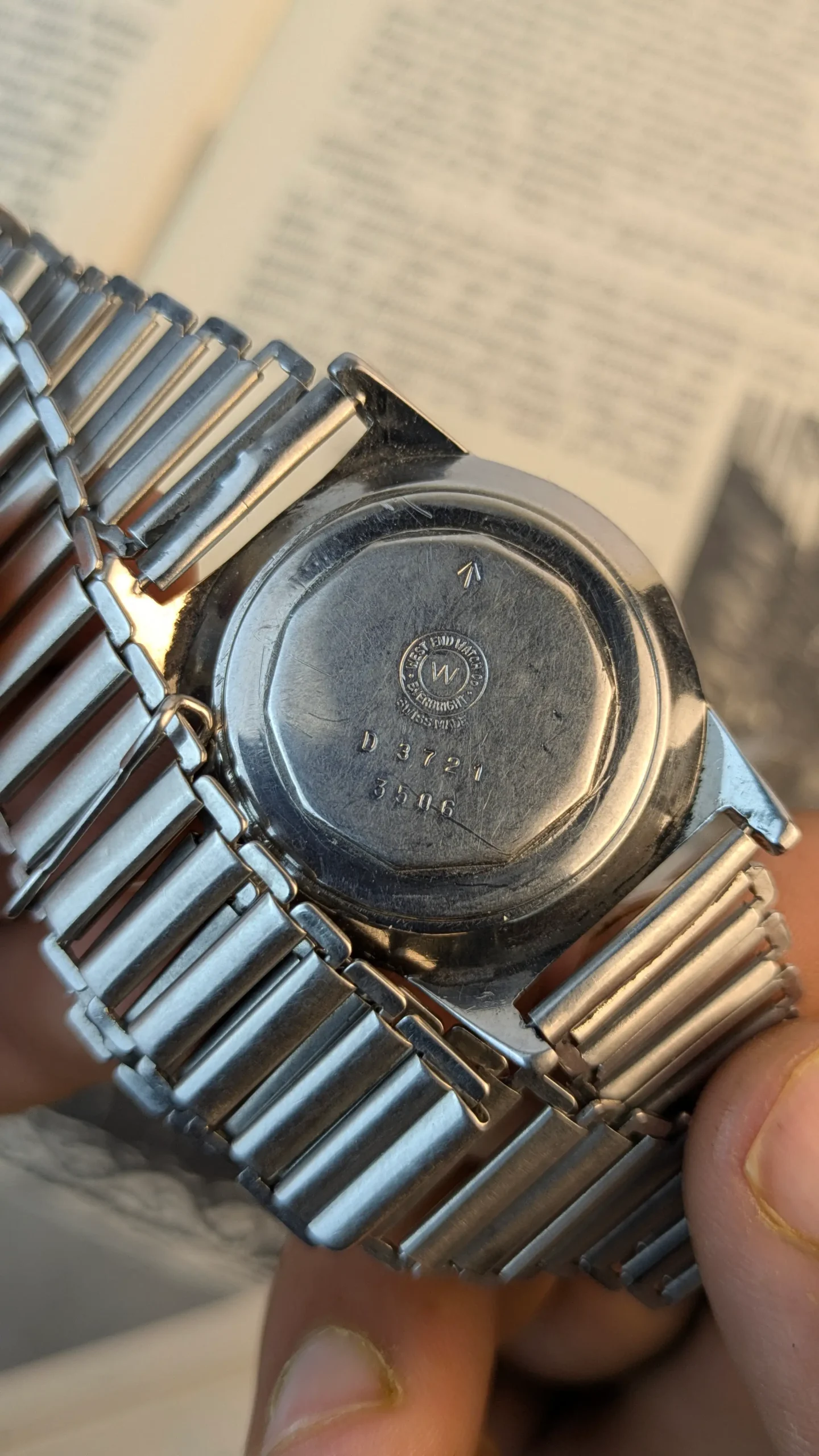 Back case of vintage West End Watch Co showing engraved markings.