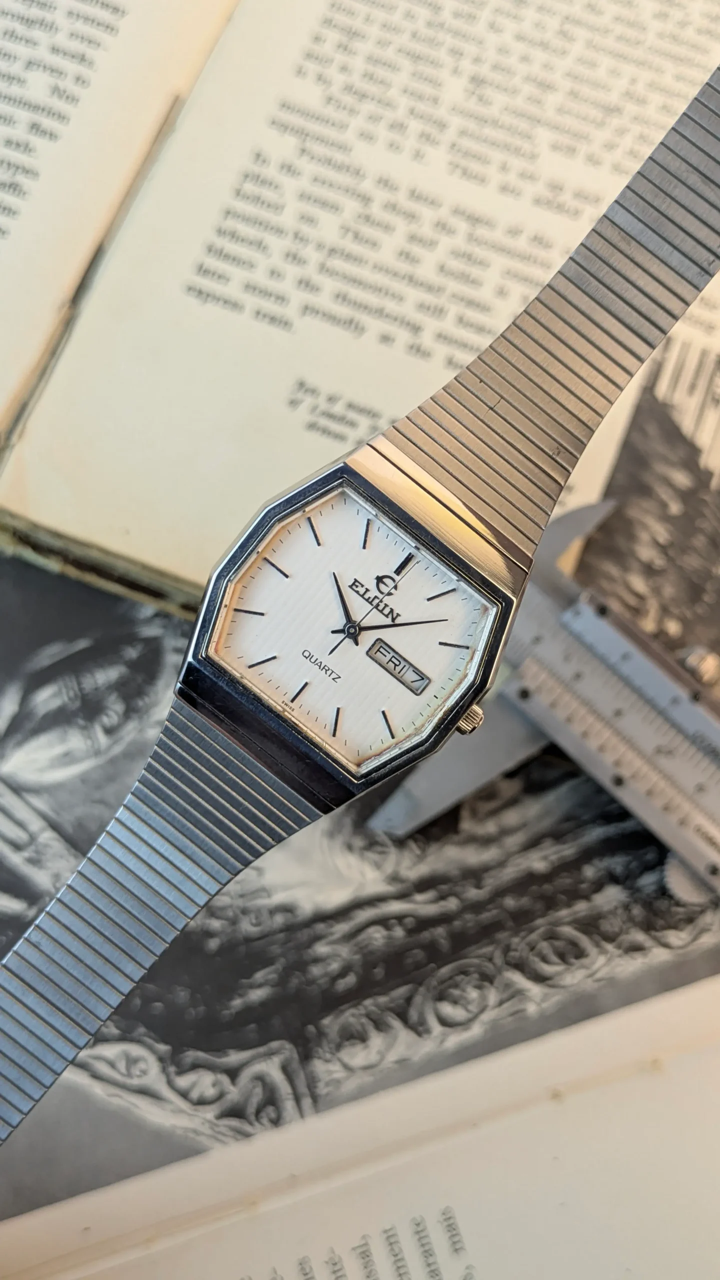 Vintage Elgin Swiss quartz watch with day date display and stainless steel bracelet.