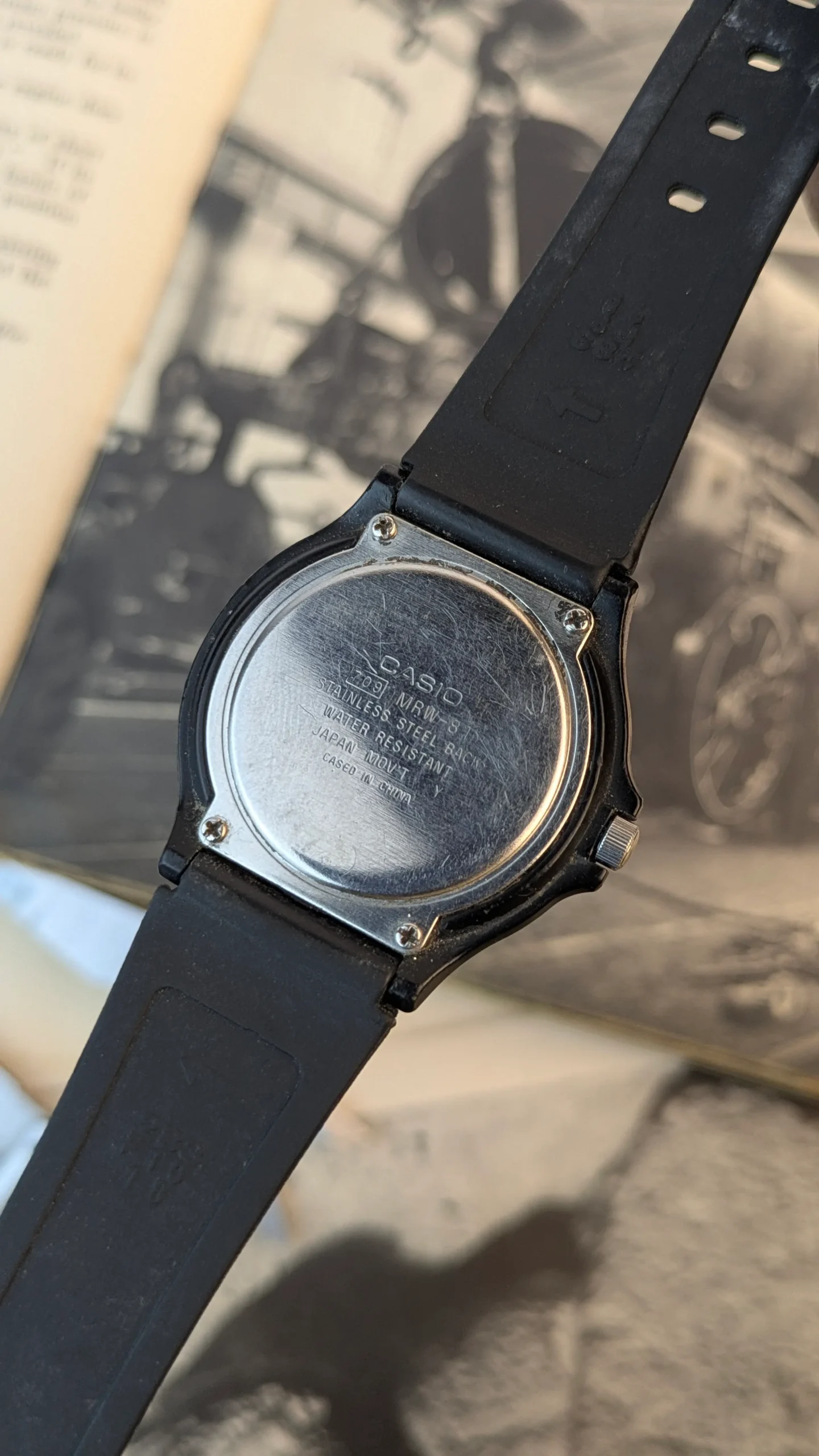 Stainless steel case back of Casio MRW-200H displaying model and water resistance details.