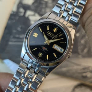 Close-up of black dial Citizen Automatic 21 Jewels watch with day-date display.