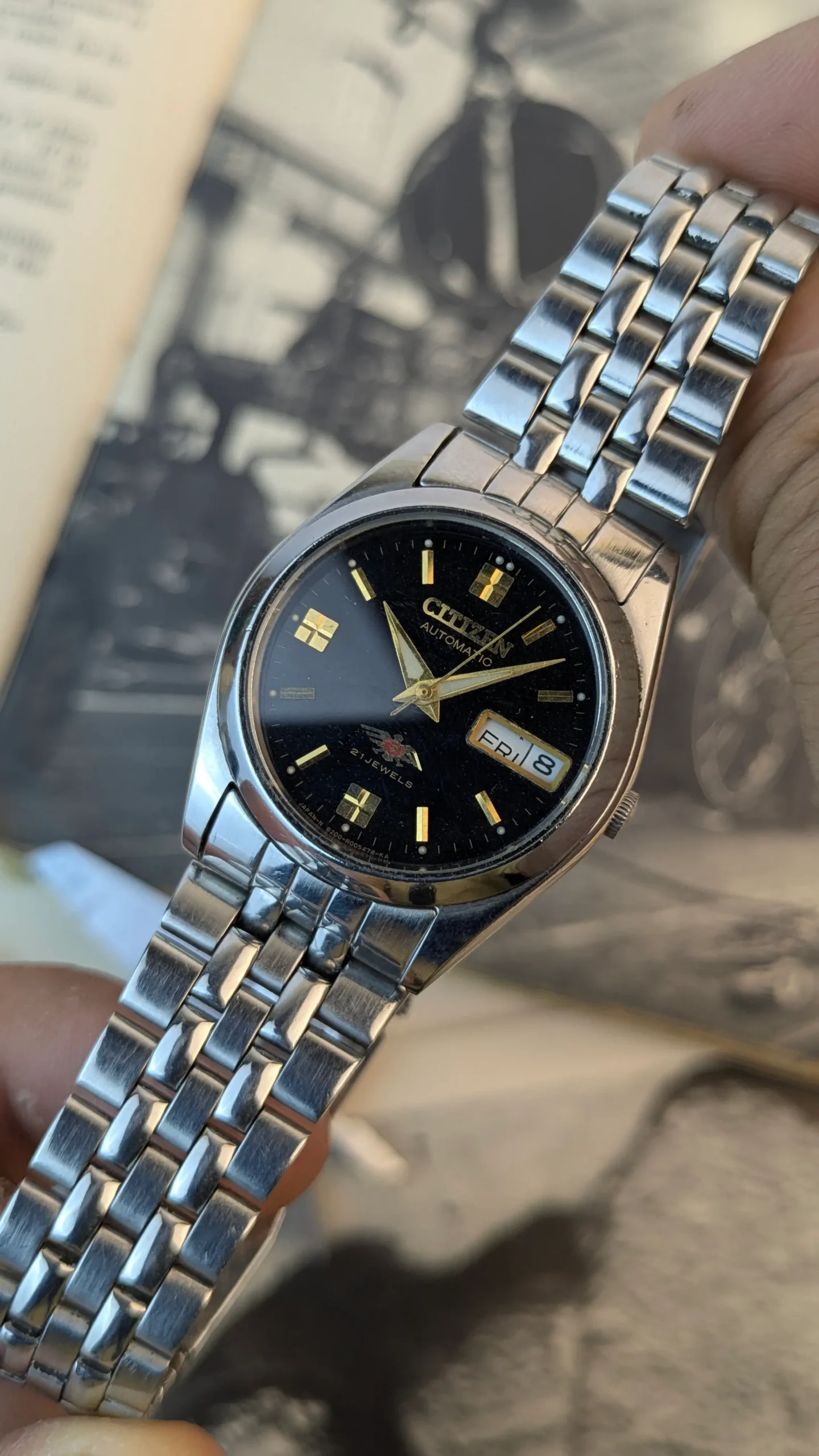 Close-up of black dial Citizen Automatic 21 Jewels watch with day-date display.